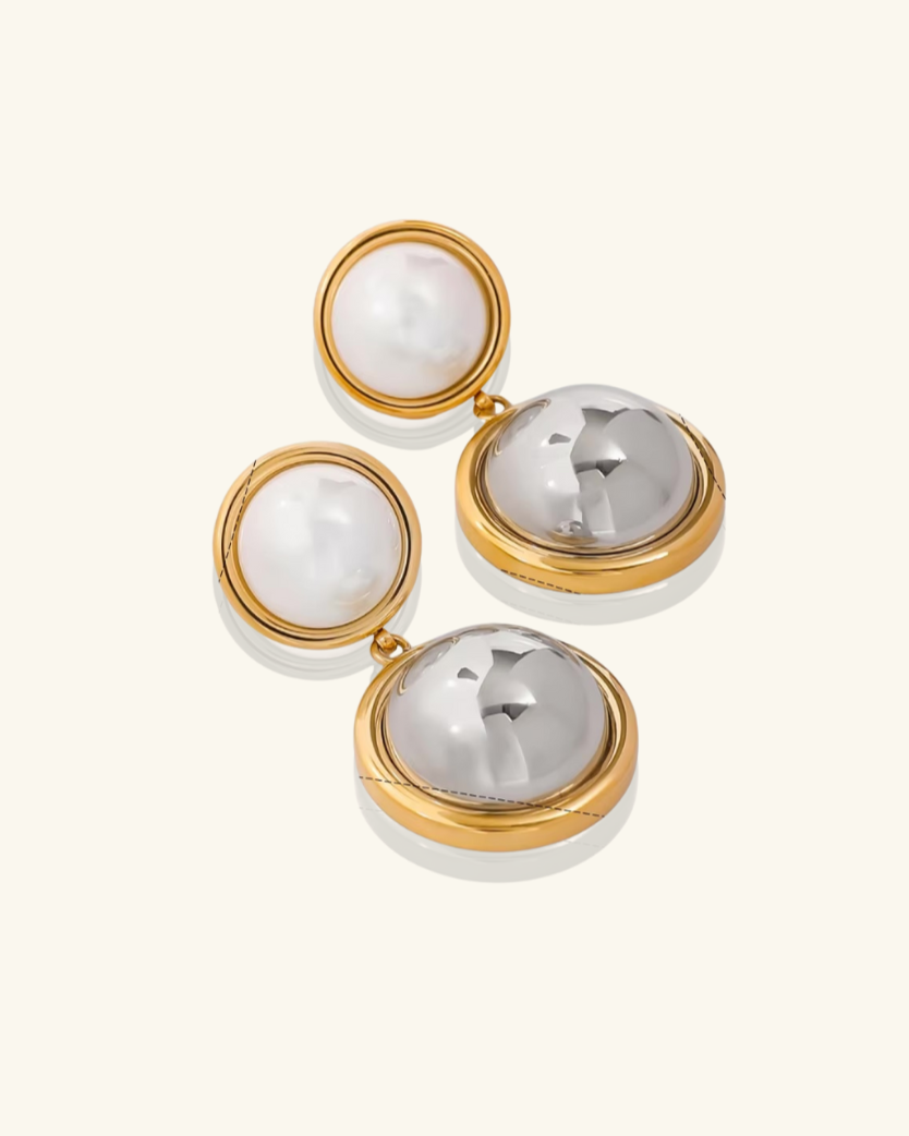 Pair of earrings with gold and silver components on a white background